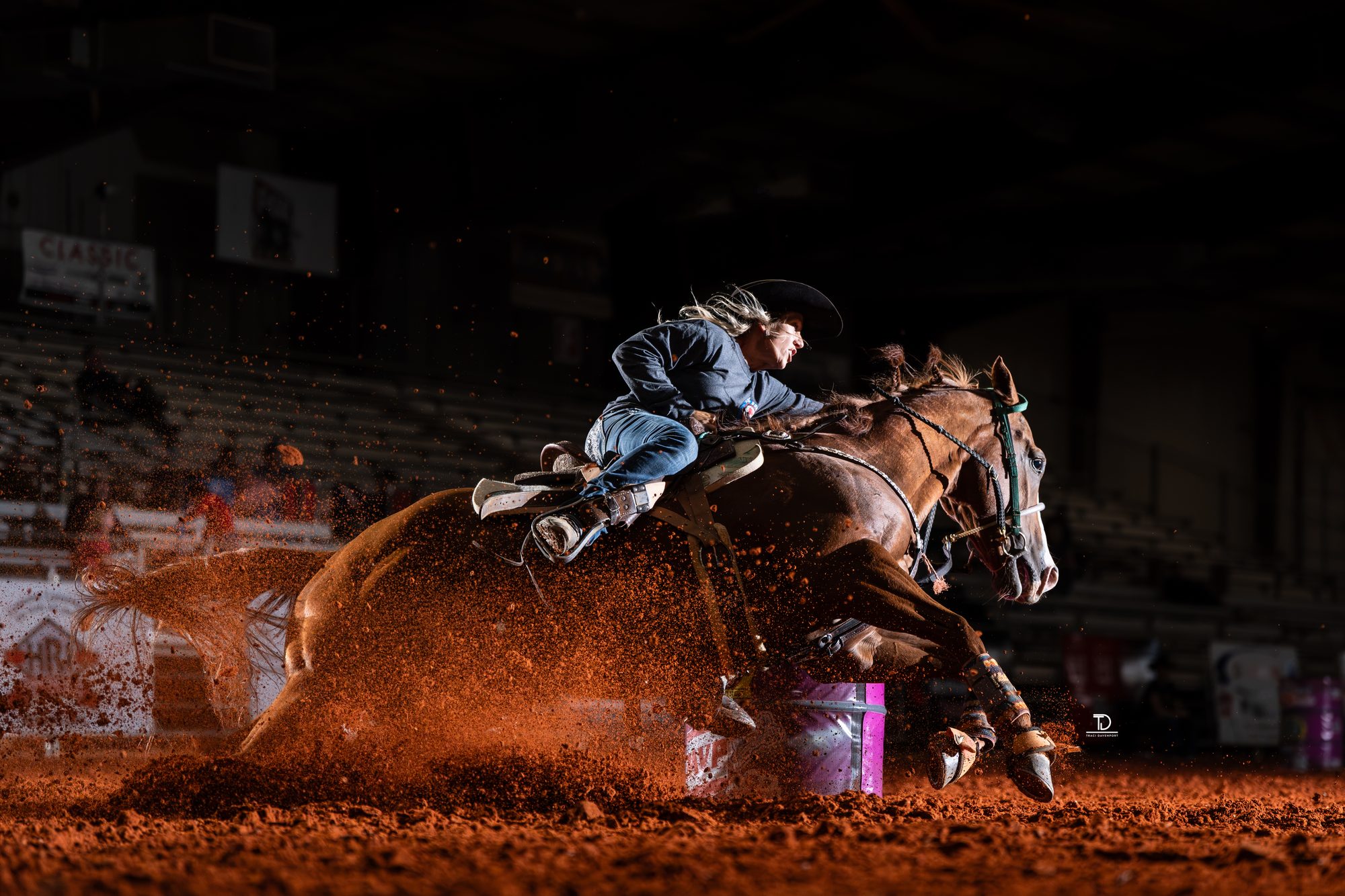 Barrel racer Bert Skimehorn turning a barrel in red dirt, photographed by Traci Davenport