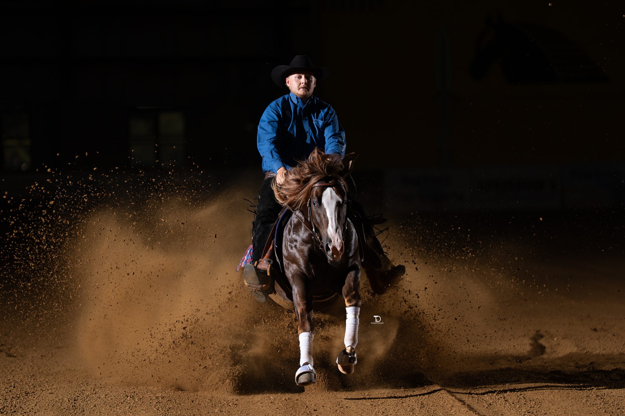 Reiner Cade McCutcheon in a sliding stop under arena lights, photographed by Traci Davenport