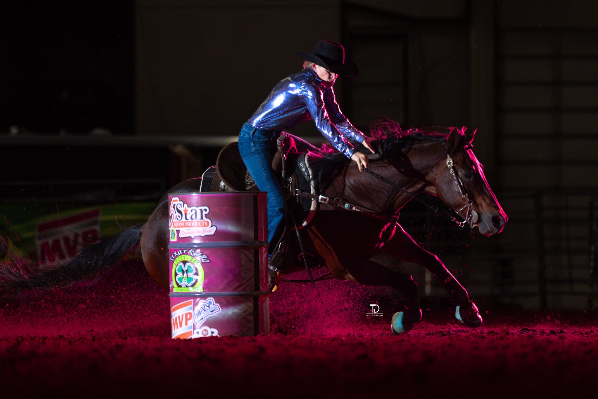 Randee Prindle barrel racing under arena lights, photographed by Traci Davenport